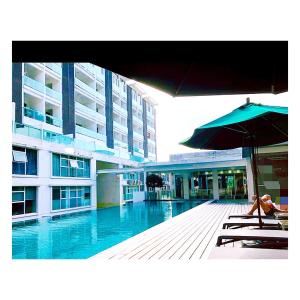 a person sitting on a chair next to a swimming pool at Corporate hotel suites at hartamas / mont kiara in Kuala Lumpur