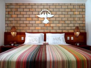 um quarto com uma cama grande e uma parede de tijolos em Pousada Sagi Iti em Baía Formosa