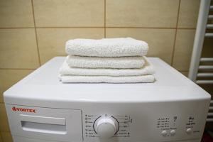 einen Stapel Handtücher auf der Waschmaschine in der Unterkunft Aparthotel Riana in Floreşti