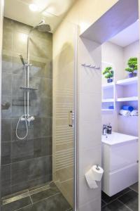 een badkamer met een douche en een wastafel bij Apartmani Plazibat in Mandre