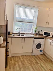 a kitchen with a sink and a washing machine at Beautiful 2 bedroom flat in Camden in London