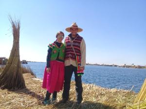 a man and woman standing next to a body of water at Titicaca in Puno