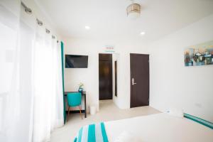 sypialnia z łóżkiem i biurkiem z niebieskim krzesłem w obiekcie Asilé Hotel Boutique w mieście Bacalar