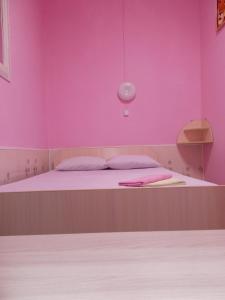 オムスクにあるМини отель "Z"のピンクの壁のベッド付きのピンクのベッドルーム