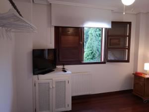 Televízia a/alebo spoločenská miestnosť v ubytovaní Apartamento Ruiloba