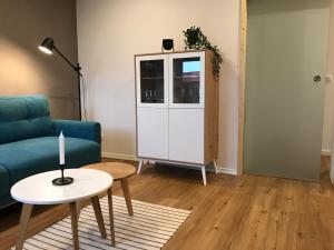 a living room with a blue couch and a table at Ferienwohnung Siedlungsnest in Anklam