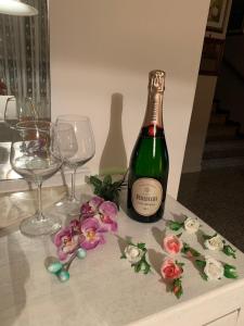 een fles champagne met twee glazen en bloemen bij B&B Amy&Julie in Badia Polesine