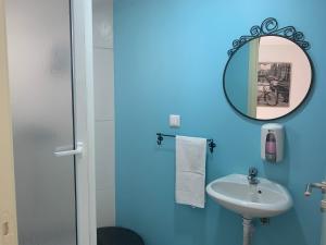 a blue bathroom with a sink and a mirror at Bike Suite in Figueira da Foz +28 photos