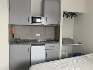 a small kitchen with a sink and a microwave at Bike Suite in Figueira da Foz