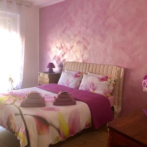 マレスコにあるAppartamento Il Porticoのピンクの壁のベッドルーム1室
