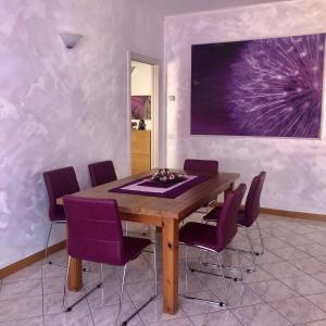 マレスコにあるAppartamento Il Porticoのダイニングルーム(木製テーブル、紫色の椅子付)