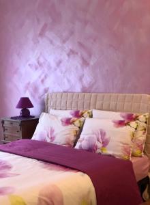 1 dormitorio con 1 cama con pared morada en Appartamento Il Portico, en Malesco
