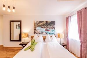 - une chambre avec un lit blanc et 2 lampes dans l'établissement NaturparkResort Haus der Hoamatlegenden, à Landl
