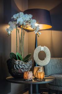 a table with a vase of flowers and a lamp at The 0507 A Luxury Flat in Antwerp in Antwerp