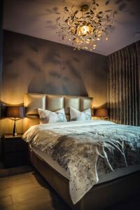 a bedroom with a large bed with a chandelier at The 0507 A Luxury Flat in Antwerp in Antwerp