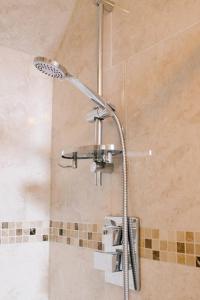 a shower with a shower head in a bathroom at Prince of Wales - Townhouse in London