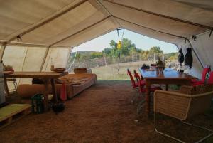 a tent with tables and chairs in a field at Safaritent Heidschnuckenhof das Camp in Niedermeiser