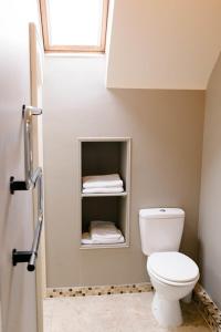 a bathroom with a toilet and a window and towels at Prince of Wales - Townhouse in London