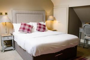 a bedroom with a large bed with two checked pillows at Prince of Wales - Townhouse in London