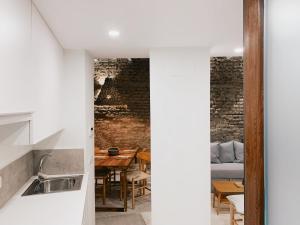 a kitchen and dining room with a brick wall at Boutike Apartments in Seville