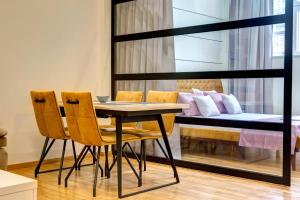 莫斯塔尔APARTMANI DOLINA SUNCA的一间有桌子、椅子和床的房间