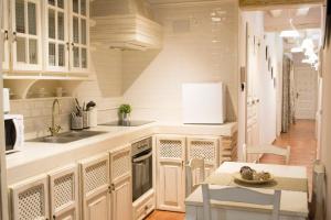 - une cuisine avec des placards blancs, une table et un évier dans l'établissement Apartamenticos Plaza Las Armas II, à Saragosse