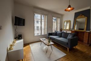 a living room with a blue couch and a mirror at Grand F2 refait à neuf, Plein coeur Centre Ville in Coutances