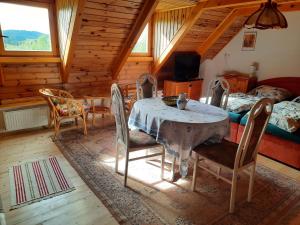a dining room with a table and chairs in a cabin at Novohradky - Oáza klidu na samotě u lesa in Benešov nad Černou