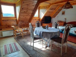 a dining room with a table and chairs in a cabin at Novohradky - Oáza klidu na samotě u lesa in Benešov nad Černou