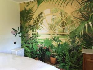 a bedroom with a bunch of plants and a bed at Ferienhaus-stadtkyll-eifel Beim Förster mit zwei Schlafzimmern in Stadtkyll
