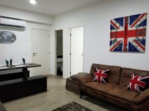 a living room with a couch and a painting on the wall at Apartamento Santos Legend in Santos