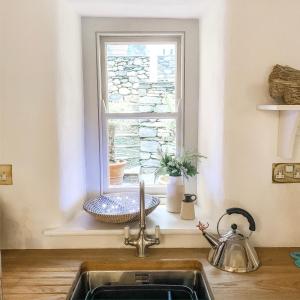 a kitchen sink in front of a window at Snowdonia Stone Cottage in Beddgelert