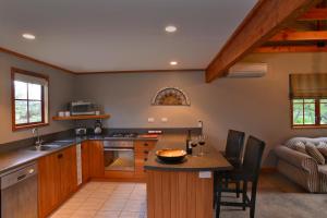 una cucina con armadi in legno e piano di lavoro di Terracotta Lodge & Cottages a Carterton