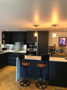 a kitchen with two bar stools at a counter at Chorlton Garden Rooms. Relax, work, stay and play. in Manchester