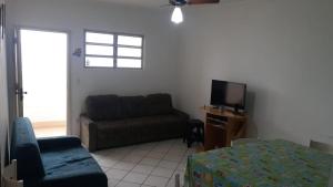 un soggiorno con divano e TV di Apartamento frente a praia a Peruíbe