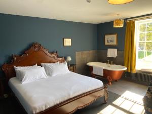 a bedroom with a bed and a tub and a sink at Lairds House in Bedlington