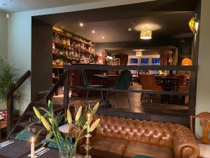 a restaurant with a leather couch in front of a bar at Lairds House in Bedlington