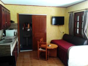 a small room with a bed and a couch and a table at Sunrise Apartments in Palekastron
