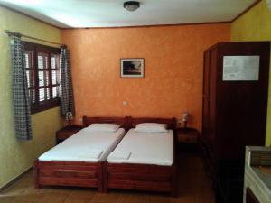 two beds in a room with orange walls at Sunrise Apartments in Palekastron