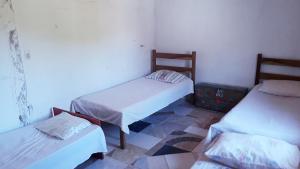 a room with two beds and a suitcase on the floor at Casa Rustica Milho Verde in Milho Verde