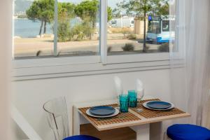 a small table with blue plates and a window at Little Bali - COSY-VUE MER - PLAGE - HOST PROVENCE in La Seyne-sur-Mer