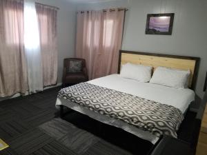 een slaapkamer met een groot bed en een stoel bij Fiesta City Motel in Montevideo
