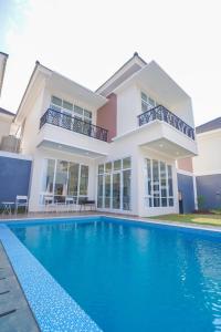 a house with a swimming pool in front of a house at Marseillia Hills in Puncak