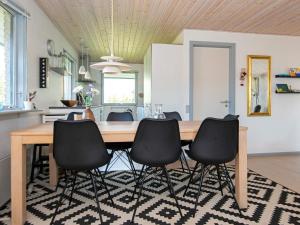 a kitchen with a wooden table and black chairs at 7 person holiday home in Knebel in Knebel