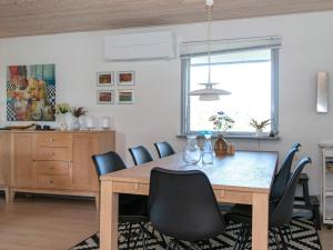 Knebelにある7 person holiday home in Knebelのダイニングルーム(木製テーブル、椅子付)