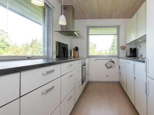 een keuken met witte kasten en een groot raam bij 7 person holiday home in Knebel in Knebel
