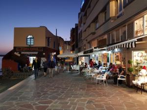 un grupo de personas caminando por una calle con mesas y sillas en Alquilaencanarias- Medano Apartment Bogavante, en El Médano