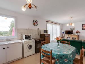 eine Küche und ein Esszimmer mit einem Tisch und einem Waschbecken in der Unterkunft Pretty holiday home with garden in Priziac in Priziac