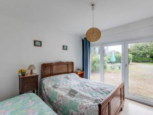 Schlafzimmer mit einem Bett und einer Glasschiebetür in der Unterkunft Pretty holiday home with garden in Priziac in Priziac