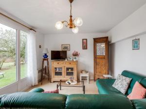 ein Wohnzimmer mit einem grünen Sofa und einem TV in der Unterkunft Pretty holiday home with garden in Priziac in Priziac